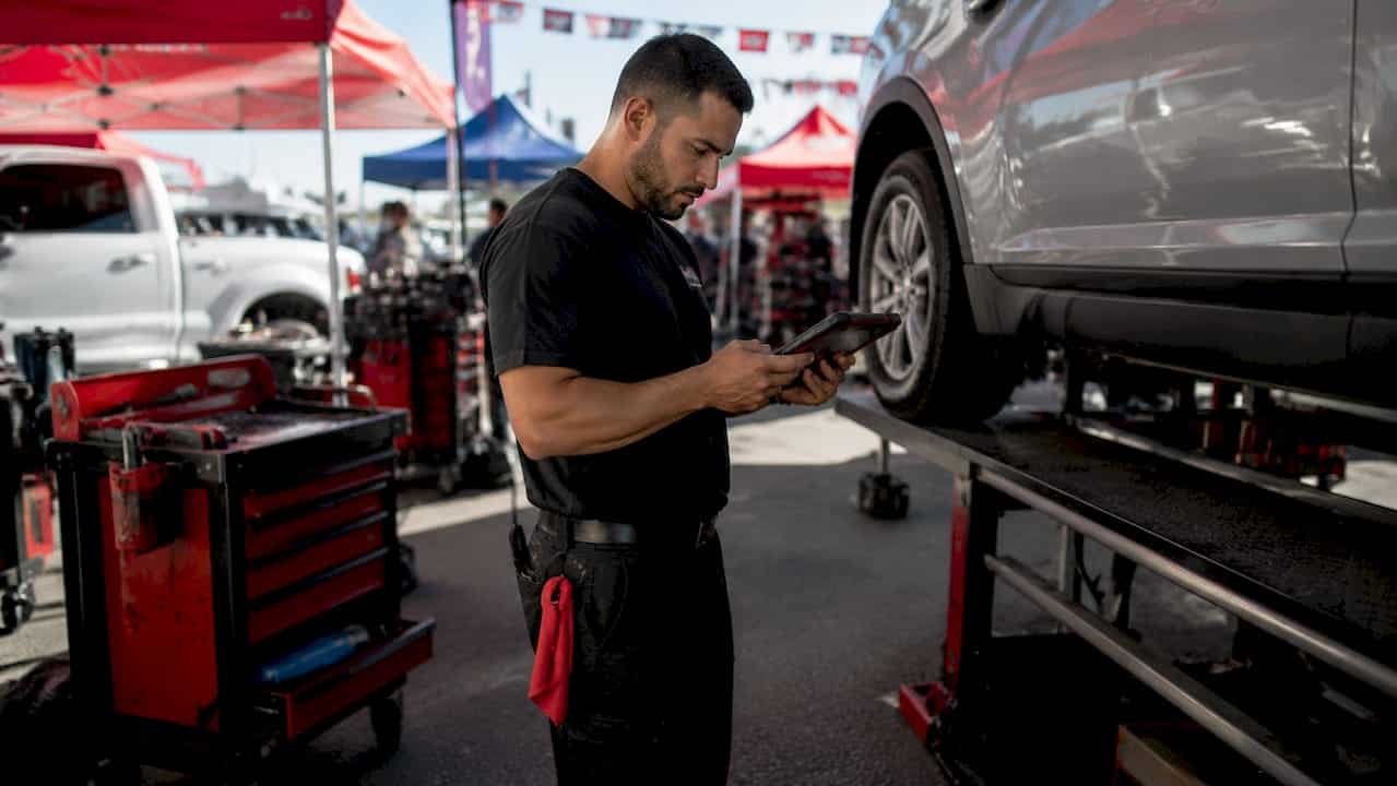 Crockett 71 Mechanic Inspecting Car With Tablet In Repair Shop