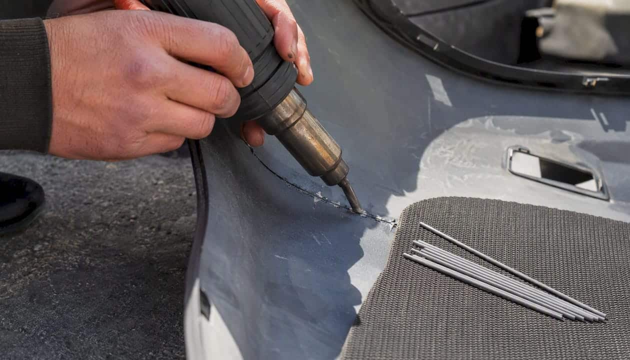 Your Complete Guide to Body Panel Repair Options 2 Hands Repairing Plastic Bumper Crack With Welding Tool