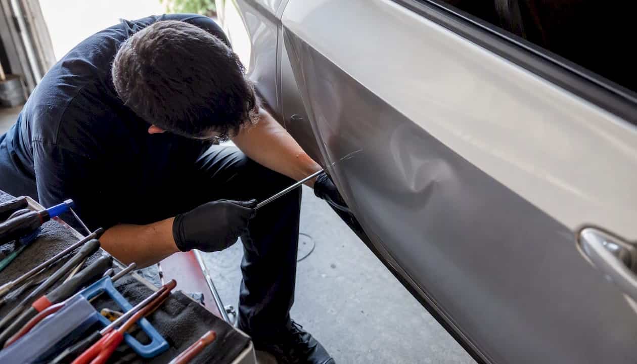 Technician performing paintless dent repair