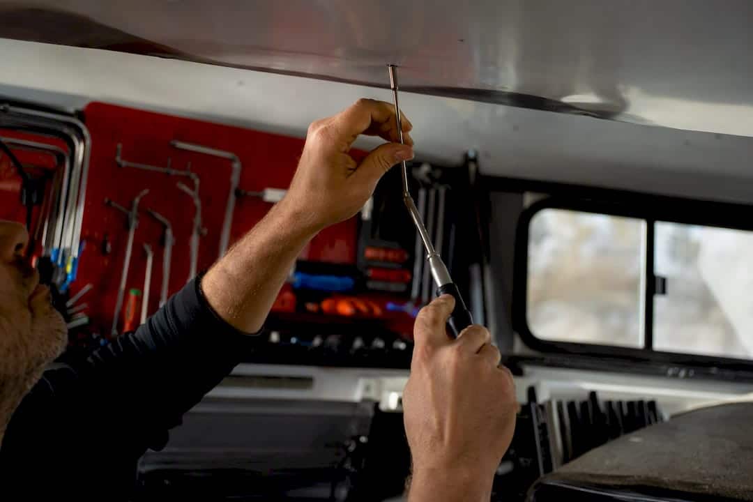 Technician repairing roof dent with PDR tools