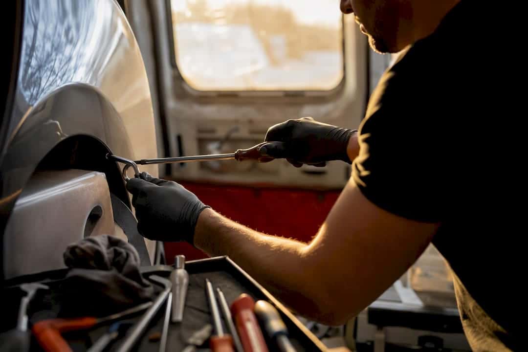 Technician hands repairing fender dent